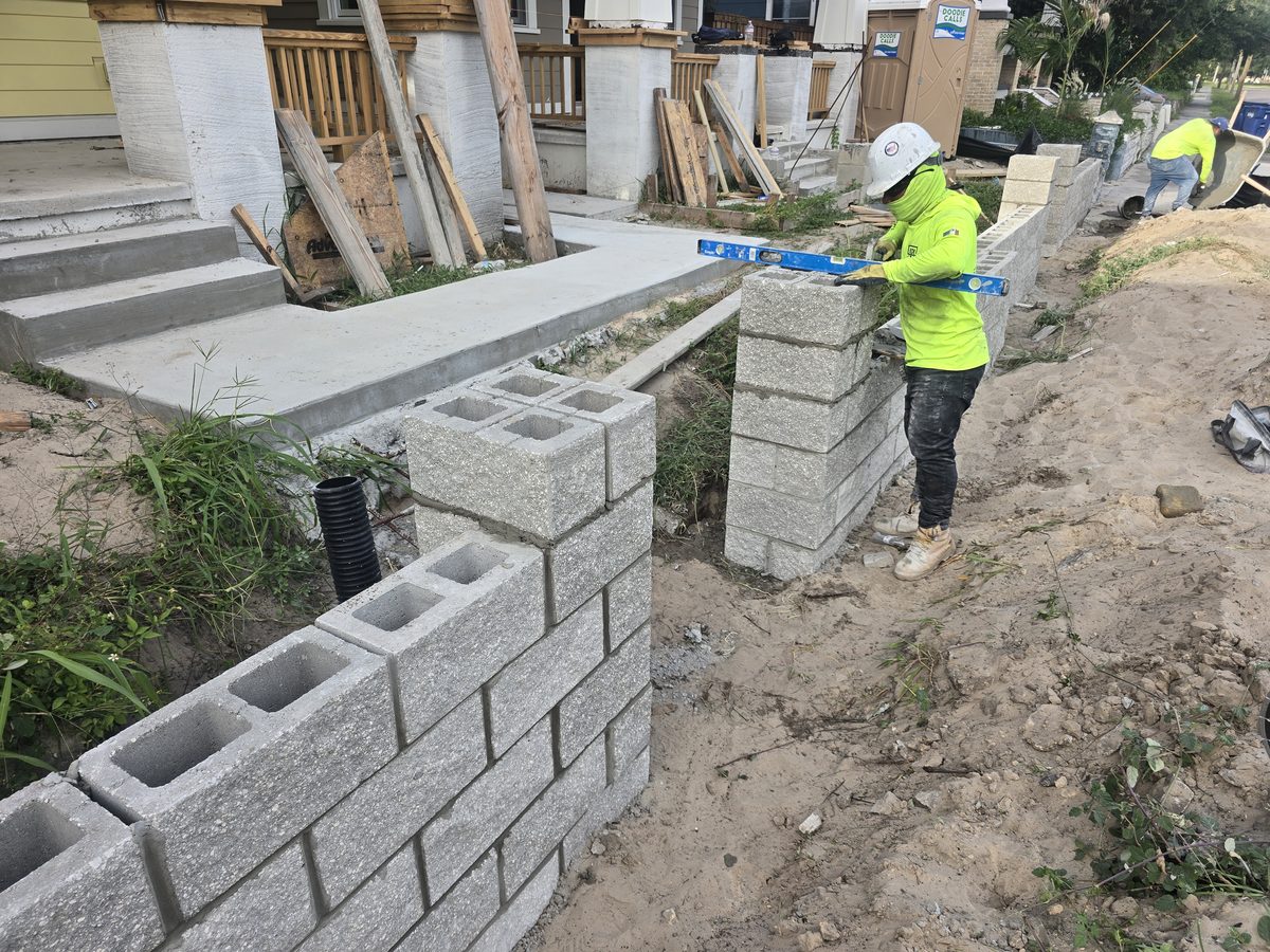 Concrete block wall installation being leveled